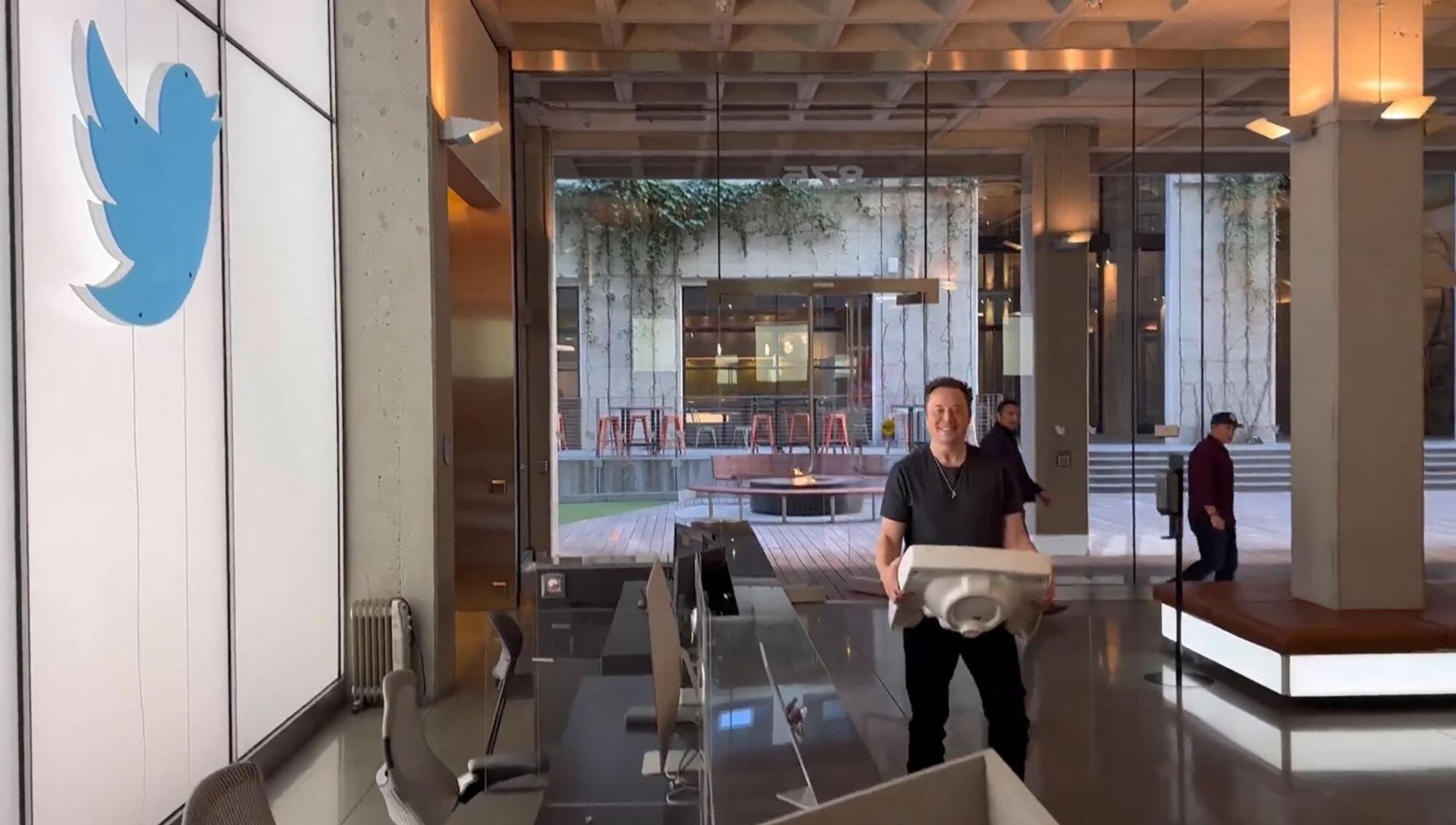 Elon Musk carrying a sink into Twitter headquarters in San Francisco.
