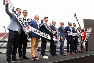 San Diego, CA - May 18: Owners and affiliates to the sport hold up San Diego MLS scarves during an event to unveil San Diego as the home of Major League Soccer's 30th franchise at Snapdragon Stadium on Thursday, May 18, 2023 in San Diego, CA. (Meg McLaughlin / The San Diego Union-Tribune)