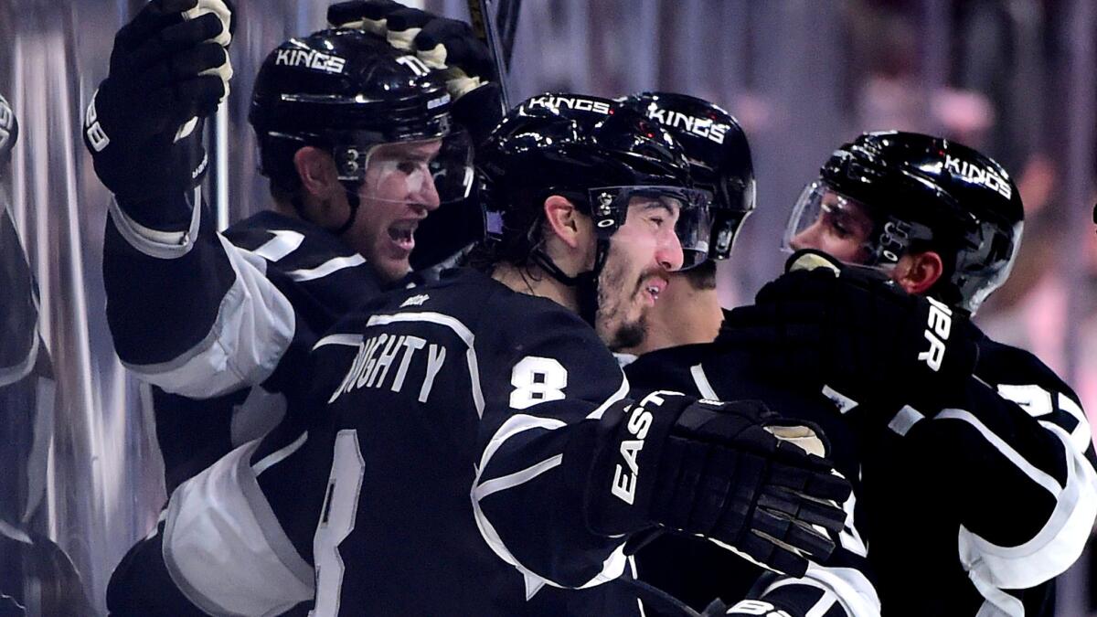 Kings center Jeff Carter, left, celebrates with teammates, including defenseman Drew Doughty, after scoring the winning goal against the Predators in overtime.