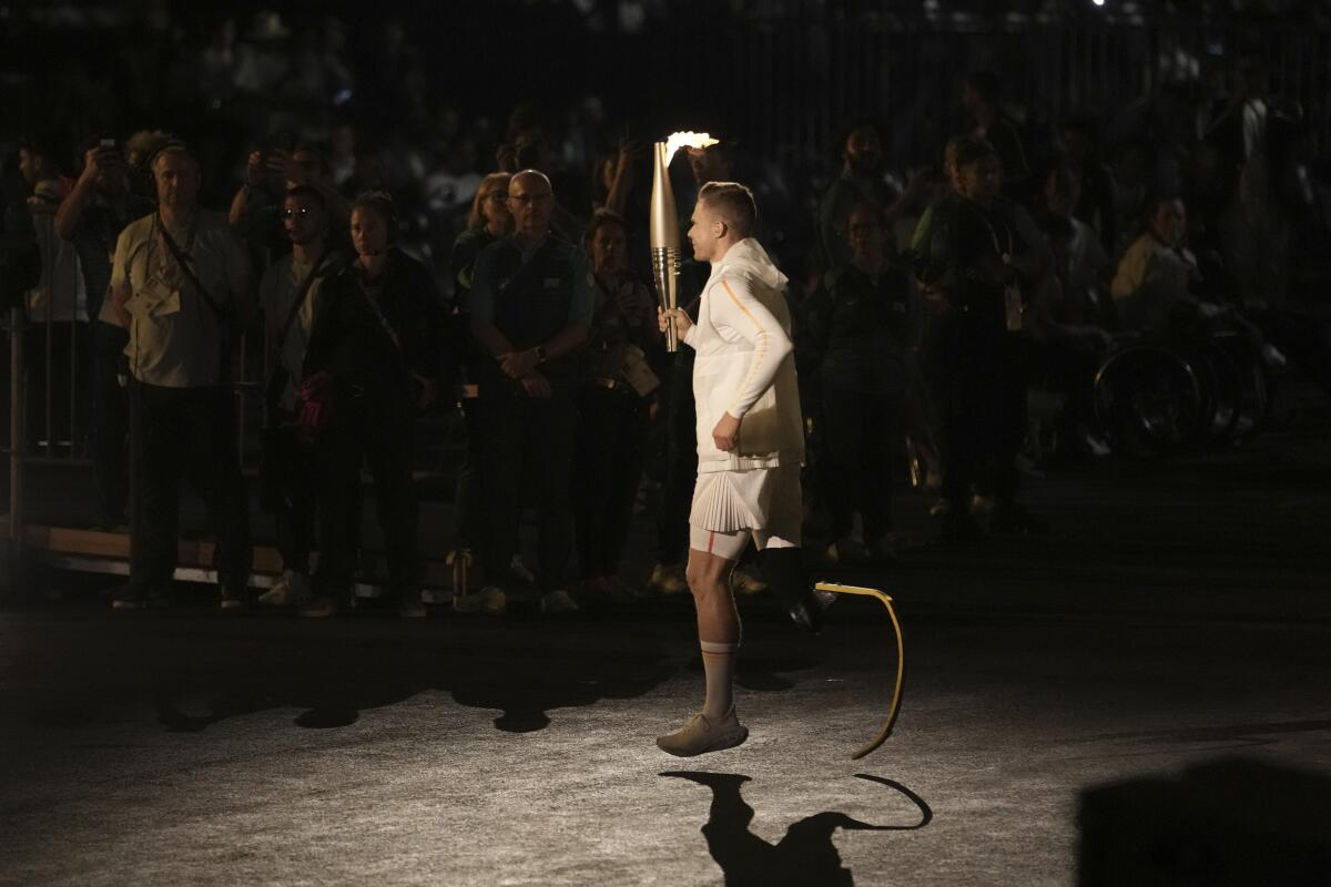 German Paralympic athlete Markus Rehm carries the torch during the opening ceremony Wednesday in Paris.