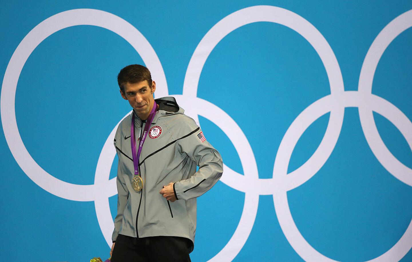 Michael Phelps leaves the podium with his 17th career Olympic gold medal after winning the men's 100m butterfly.