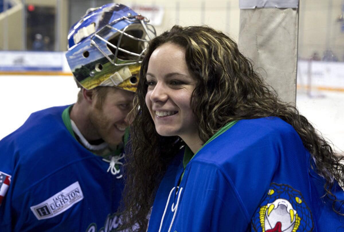 Goalie Shannon Szabados, who helped her Canadian team win gold at the Sochi Games, shares a laugh with new teammate Andrew Loewen during a timeout in a game against the Pensacola Ice Flyers on Thursday at Columbus Civic Center.