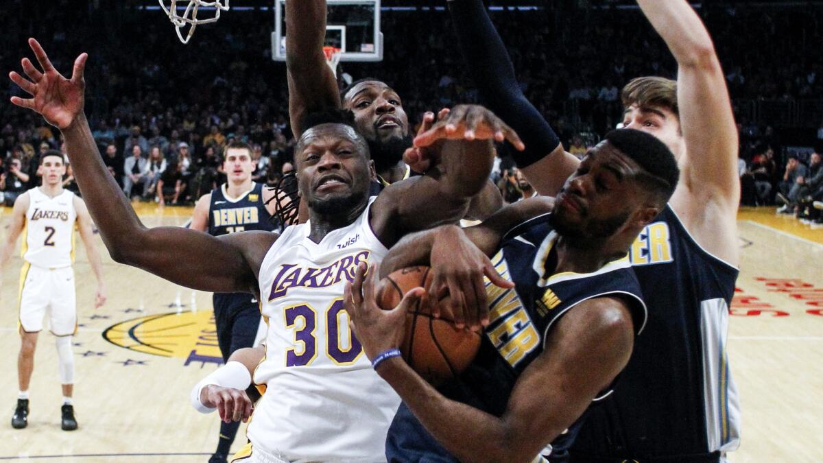 Lakers forward Julius Randle battles three Nuggets players for a rebound during their game Sunday evening.