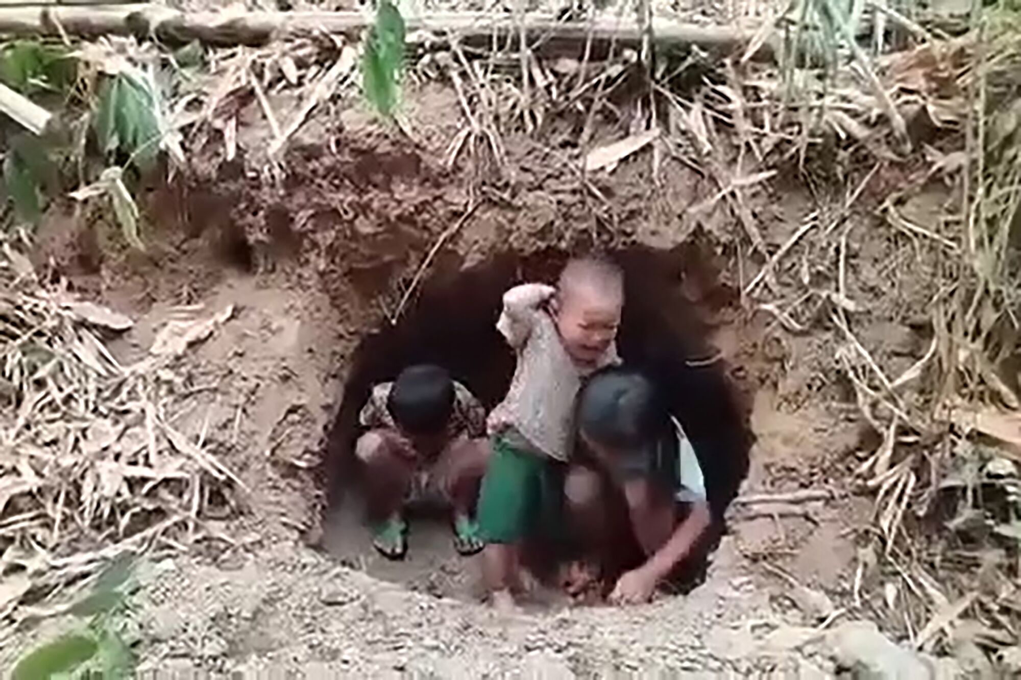 Children take shelter in a hole. 