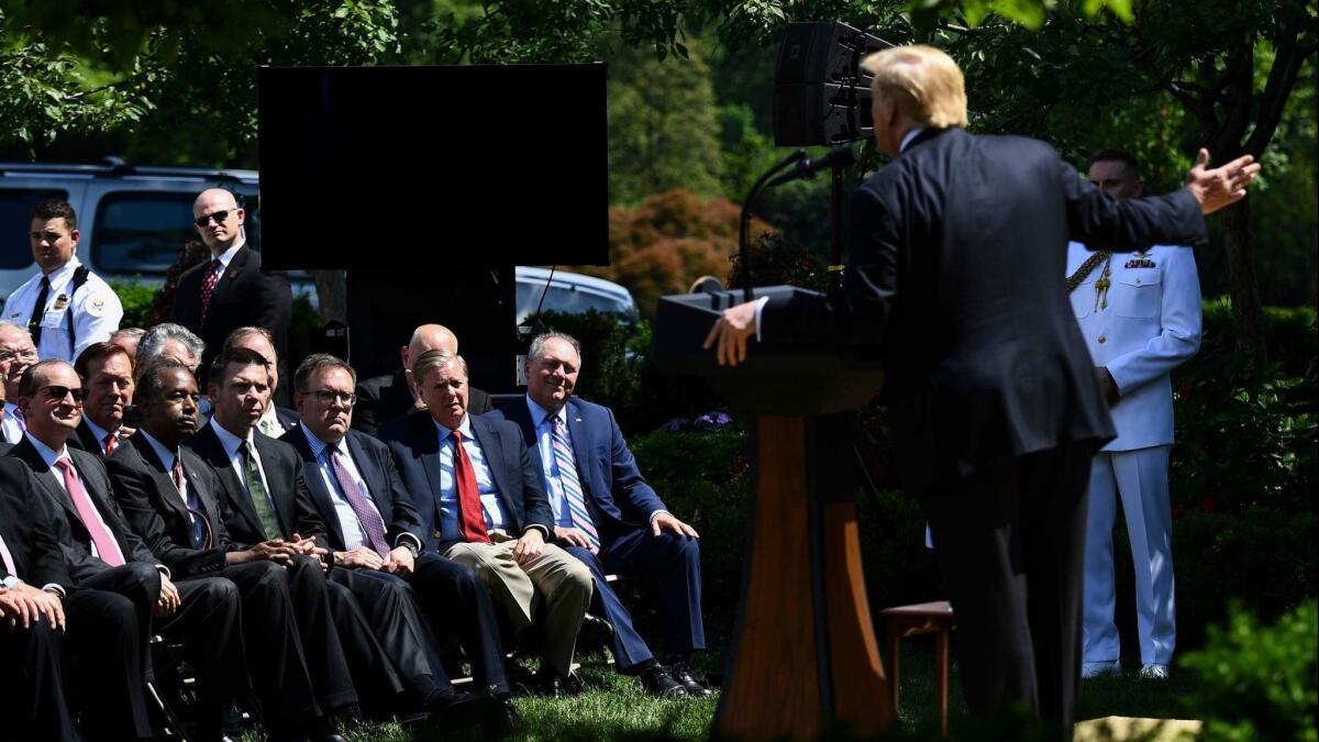 Cabinet members and senators listen to President Trump announce a new immigration proposal in the Rose Garden of the White House on May 16.