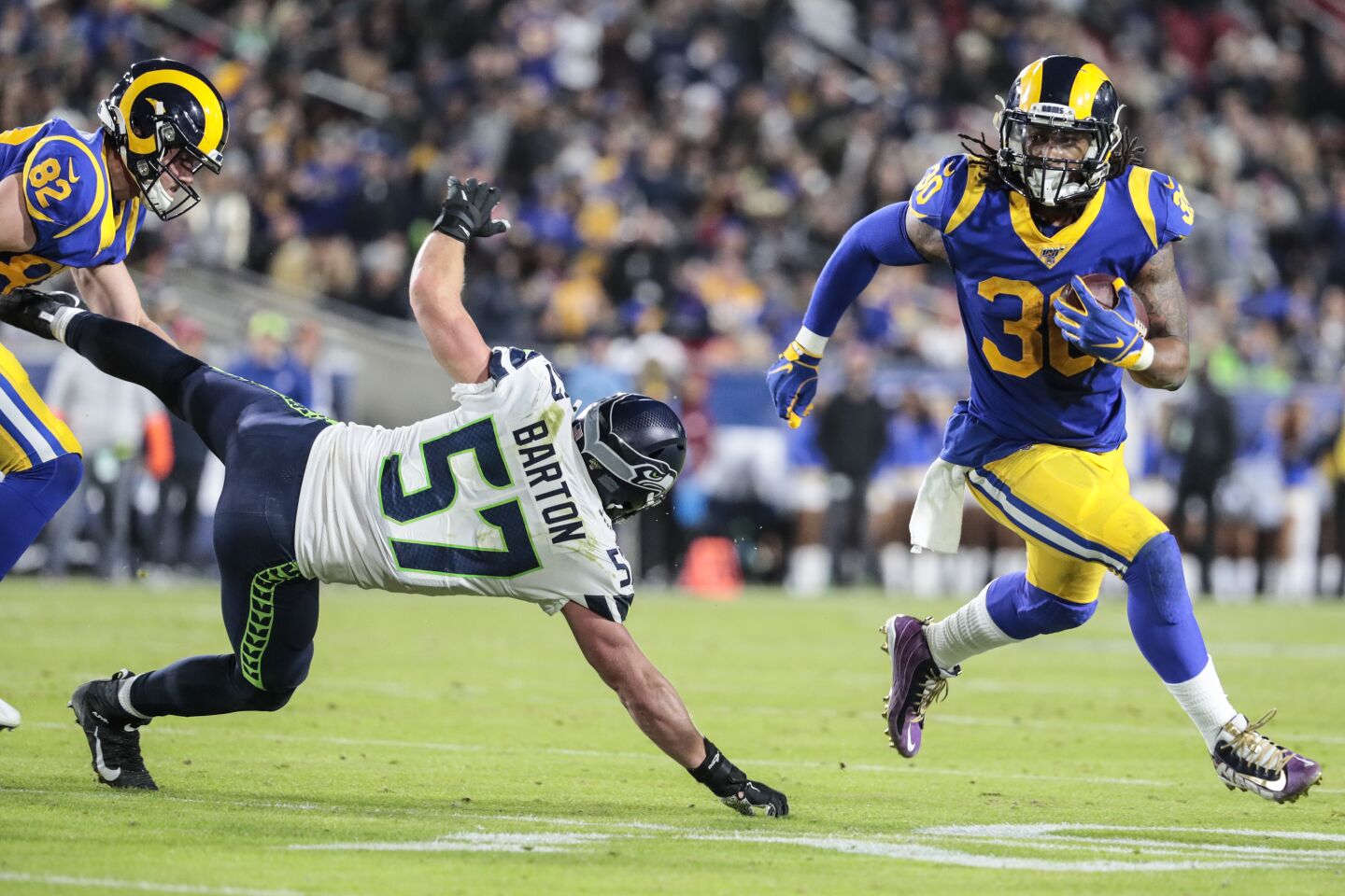 Rams running back Todd Gurley tries to sprint past Seattle Seahawks linebacker Cody Barton while carrying the ball.