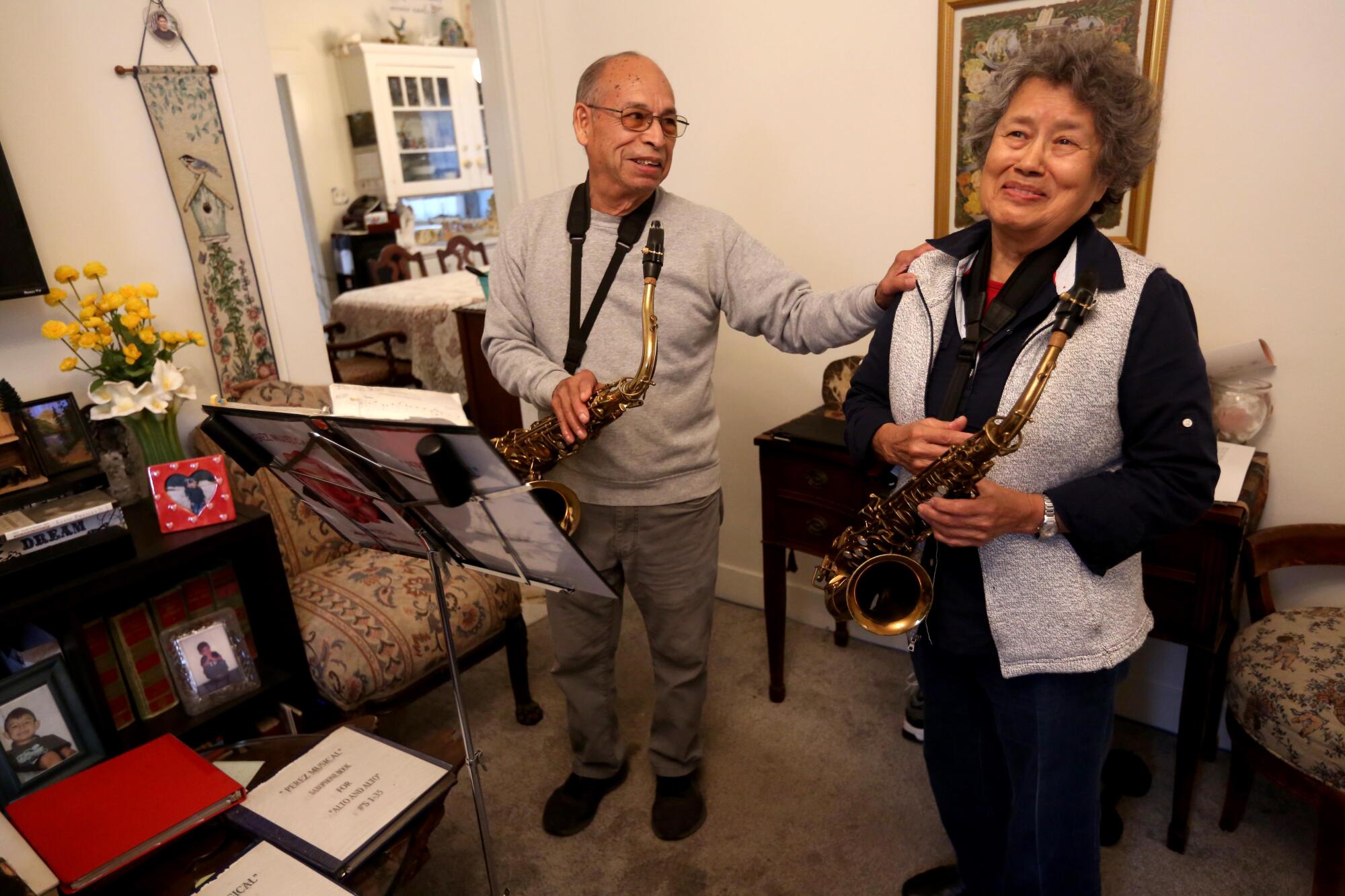 Danny Perez and his wife, Martha Perez, take a break from playing religious songs on their saxophones.