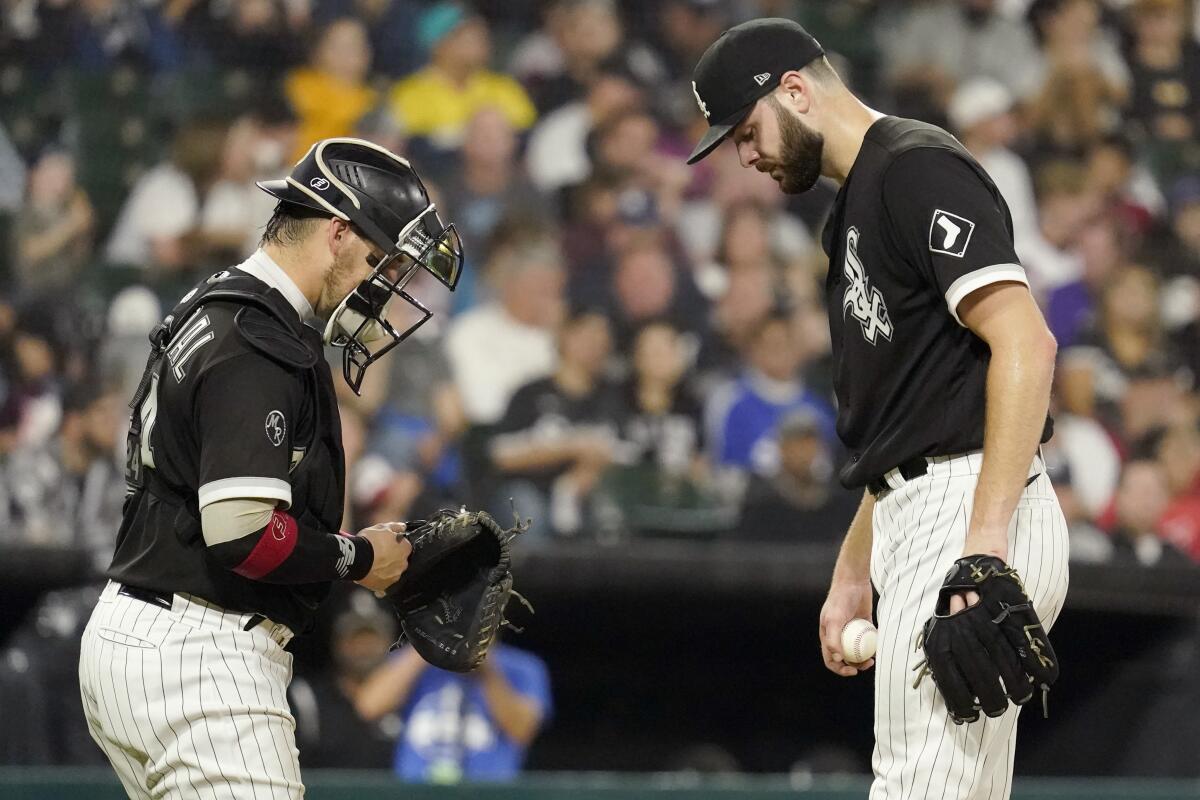 Chicago White Sox starting pitcher Lucas Giolito, right, talks with catcher Yasmani Grandal during the fourth inning of a baseball game against the Detroit Tigers in Chicago, Saturday, Oct. 2, 2021. (AP Photo/Nam Y. Huh)