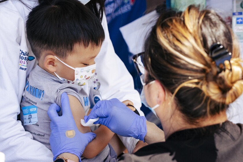 A nurse cleans a small boy's arm to prepare for an injection