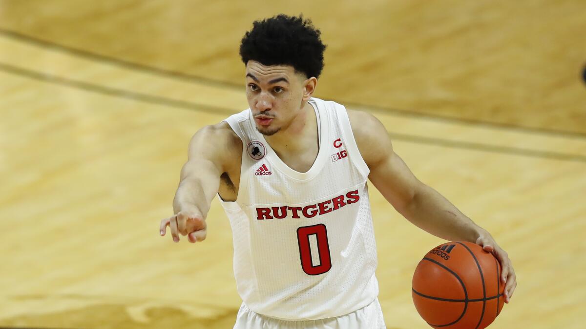 Rutgers guard Geo Baker points while handling the ball against Northwestern.