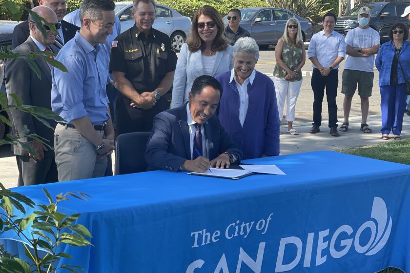 Mayor Todd Gloria signs two pieces of legislation for infrastructure funding. Councilmember Chris Cate (L) and city council president Jennifer Campbell (R) attend the conference Thursday, August 12, 2021 at Mesa Verde park on Gold Coast Drive.