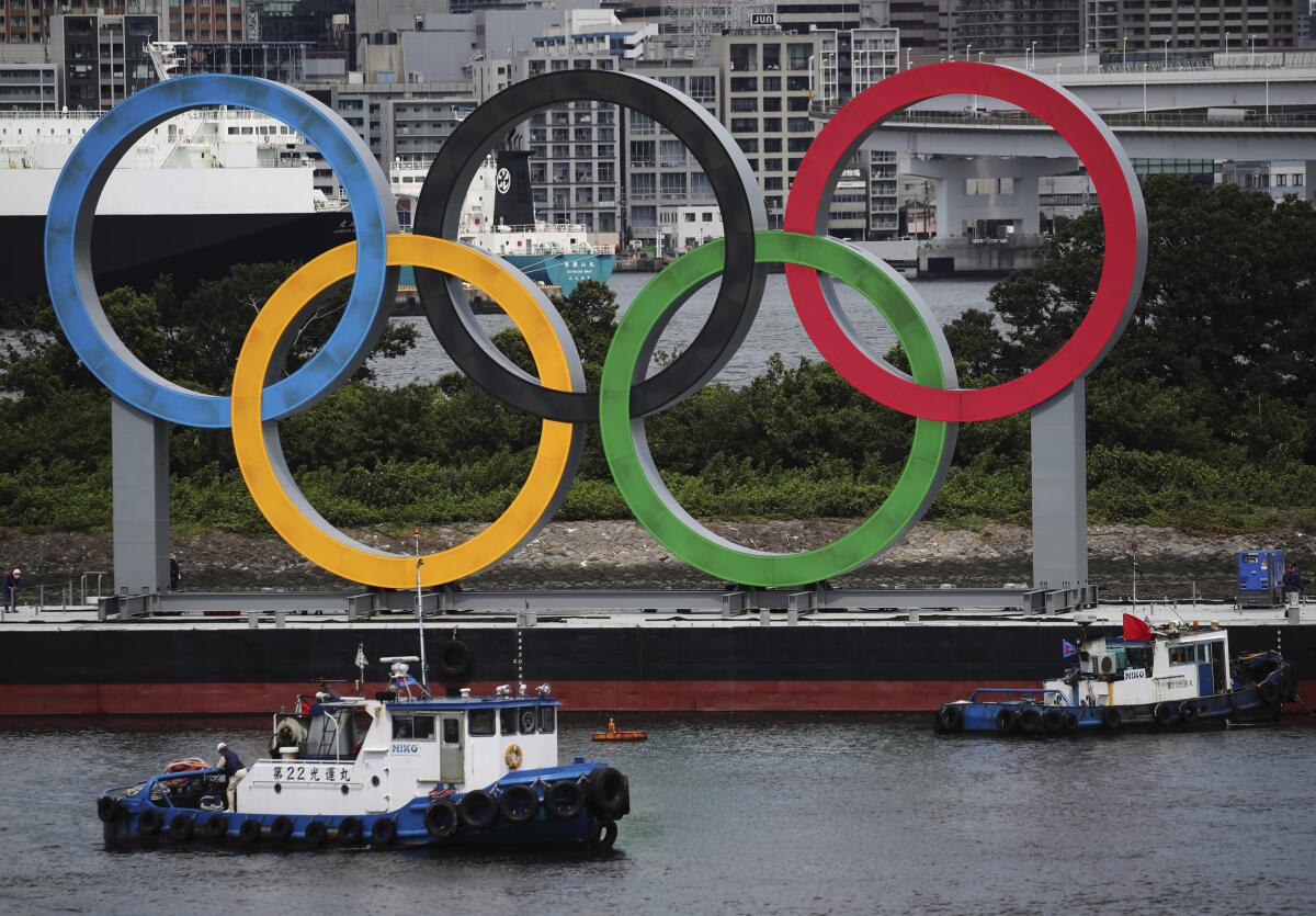 ARCHIVO - En foto del 11 de agosto del 2021, botes comienzan a quitar los aros olímpicos