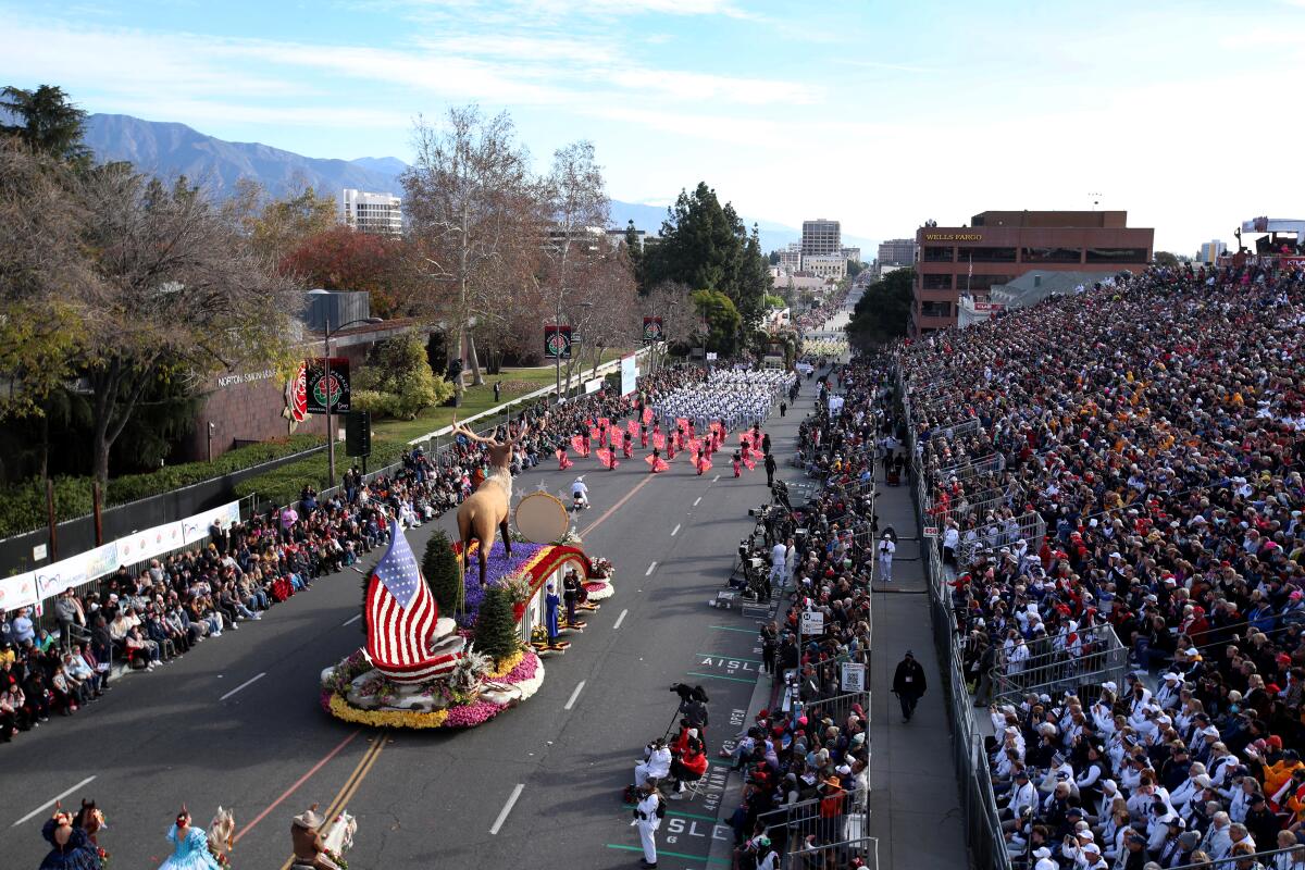 A float with an American flag design passes a grandstand