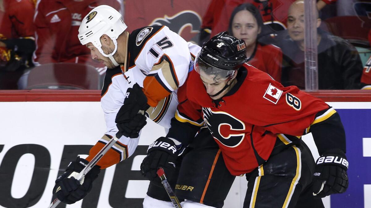 Ducks captain Ryan Getzlaf, left, is checked by Calgary Flames forward Joe Colborne as he controls the puck during the Ducks' 4-3 overtime loss in Game 3 of the Western Conference semifinals on May 5.