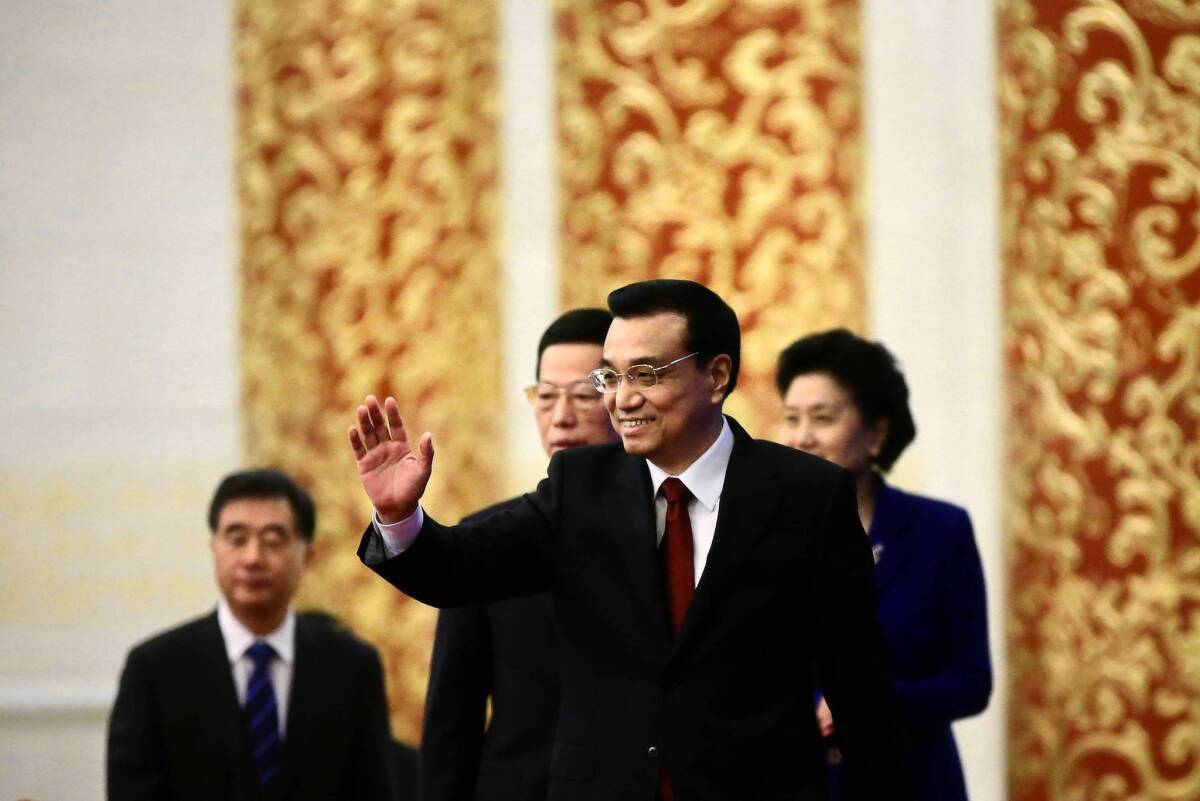 Premier Li Keqiang waves during a news conference at the Great Hall of the People in Beijing.