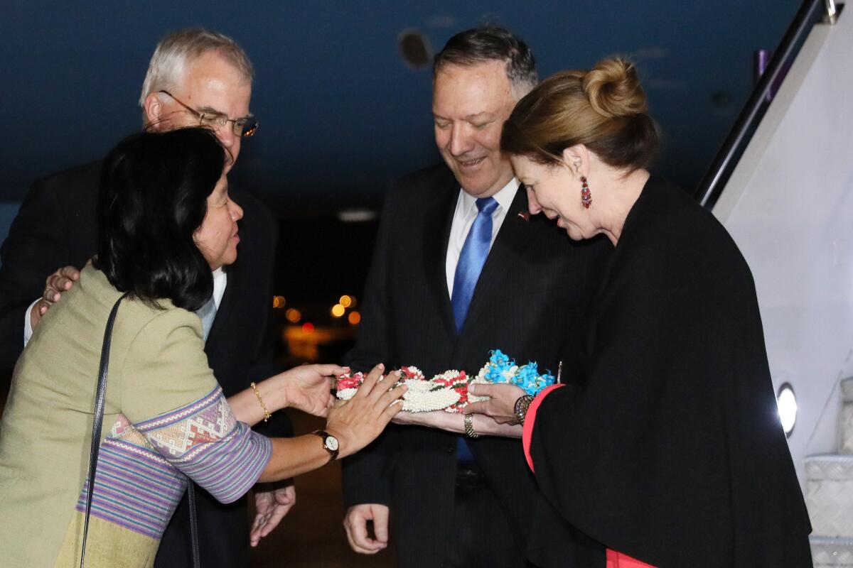 Secretary of State Michael R. Pompeo and his wife, Susan, right, are greeted with flowers by U.S. Embassy Chargé d'Affaires Peter Haymond and his wife, Dusadee, as they arrive at Don Mueang International Airport in Bangkok, Thailand, on Thursday.