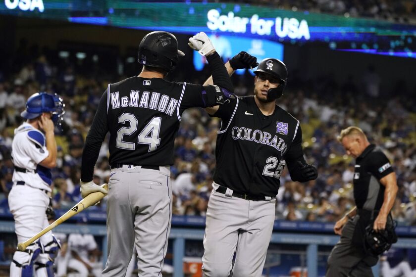 The Rockies' C.J. Cron, right, celebrates his go-ahead solo homer with Ryan McMahon during the sixth inning Aug. 27, 2021.