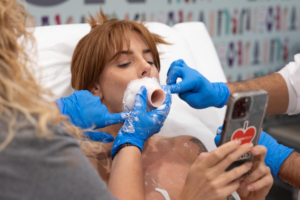 Ray takes selfies for her social media accounts while getting a plaster mold made of her open mouth.