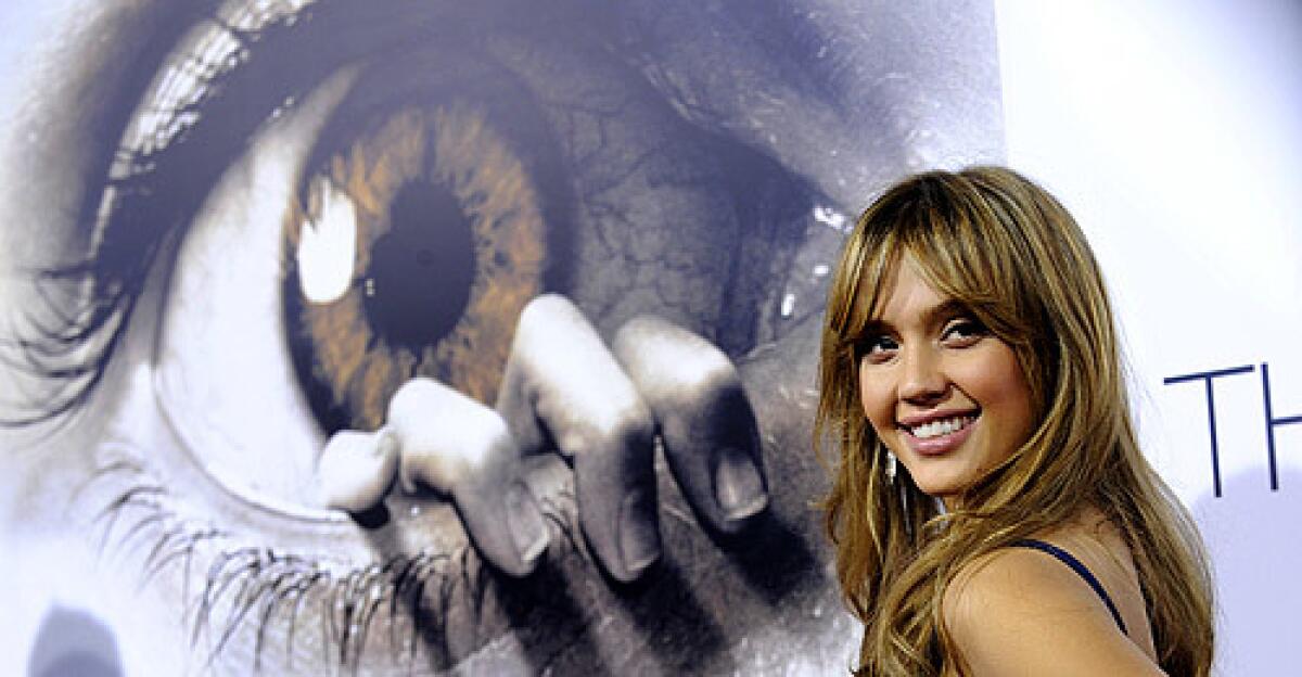 Jessica Alba, star of the horror film "The Eye," poses in front of the film's poster at the L.A. premiere.