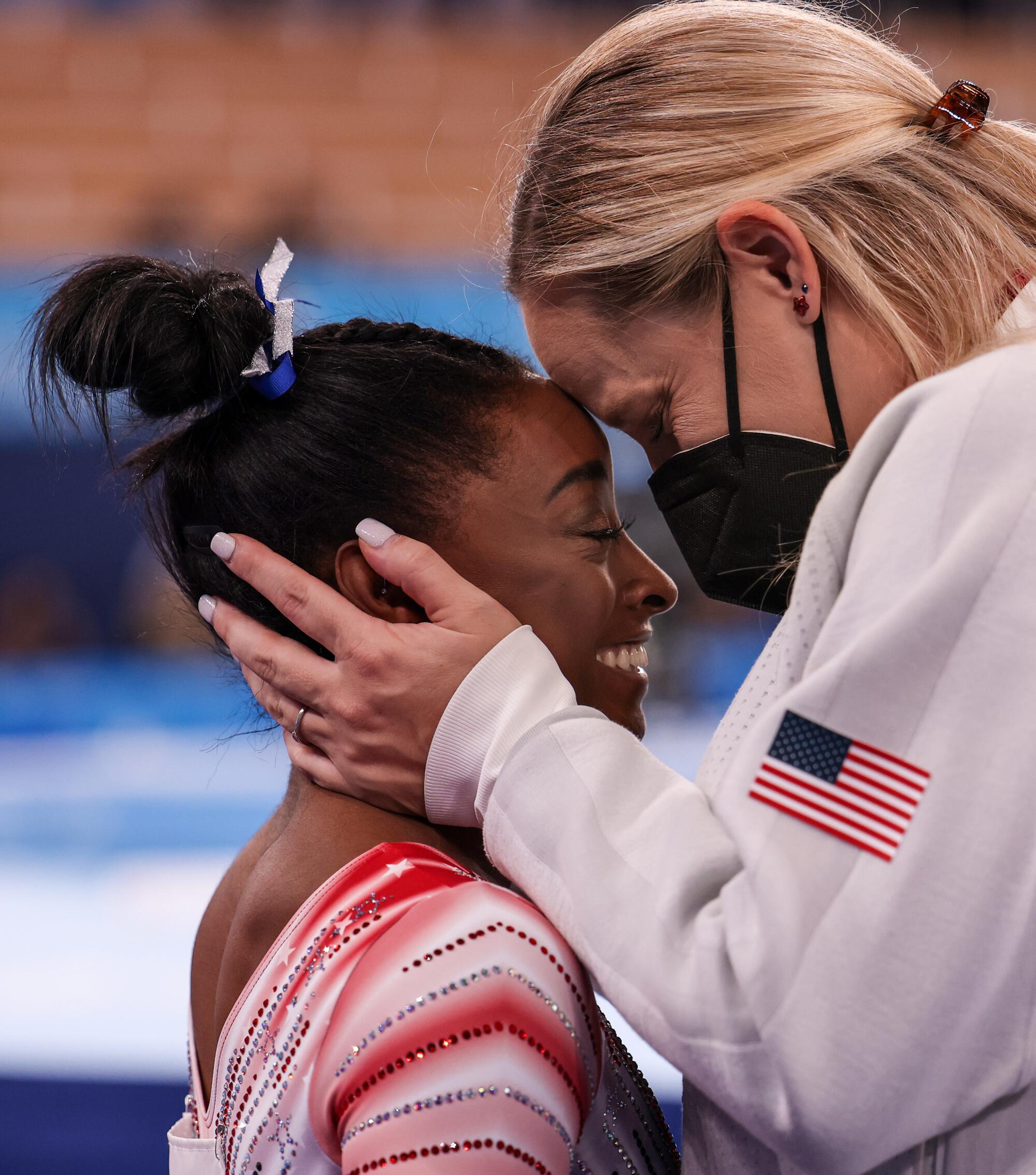 Simone Biles is embraced by Cecile Landi.