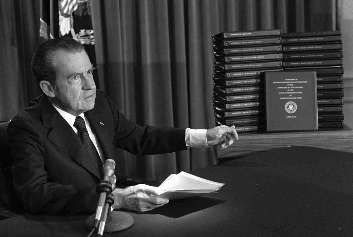 President Richard M. Nixon points to the transcripts of the White House tapes after he announced during a nationally-televised speech that he would turn over the transcripts to House impeachment investigators, in Washington in 1974.