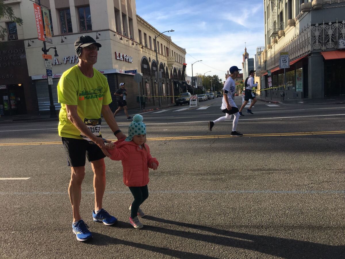 Jim Blanck, 61, takes a break from the marathon to embrace his granddaughter, Eryn.