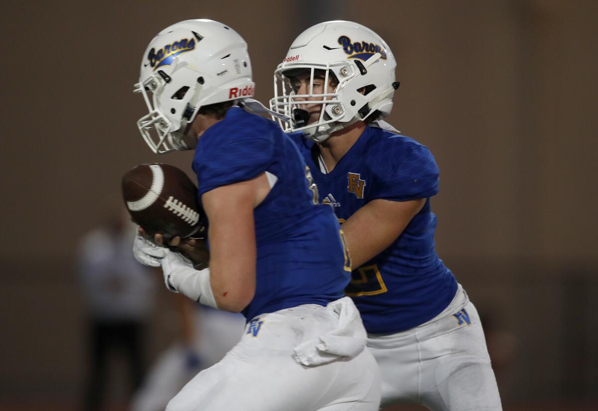 Fountain Valley's James Russell, right, shown handing the ball to Tanner Ciok against Woodbridge on Sept. 5, helped the Barons beat Agoura 42-6 on Friday at Huntington Beach High.