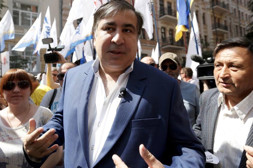 FILE - A Tuesday, May 30, 2017 file photo of former Georgian president and former governor of the Ukrainian Odessa region Mikhail Saakashvili surrounded by his supporters at a rally near the Justice Ministry in Kiev, Ukraine. Ukraine's president has rescinded the citizenship of Mikheil Saakashvili, who moved to Ukraine to become leader of one of its most corruption-plagued regions and later resigned. (AP Photo/Sergei Chuzavkov, File)