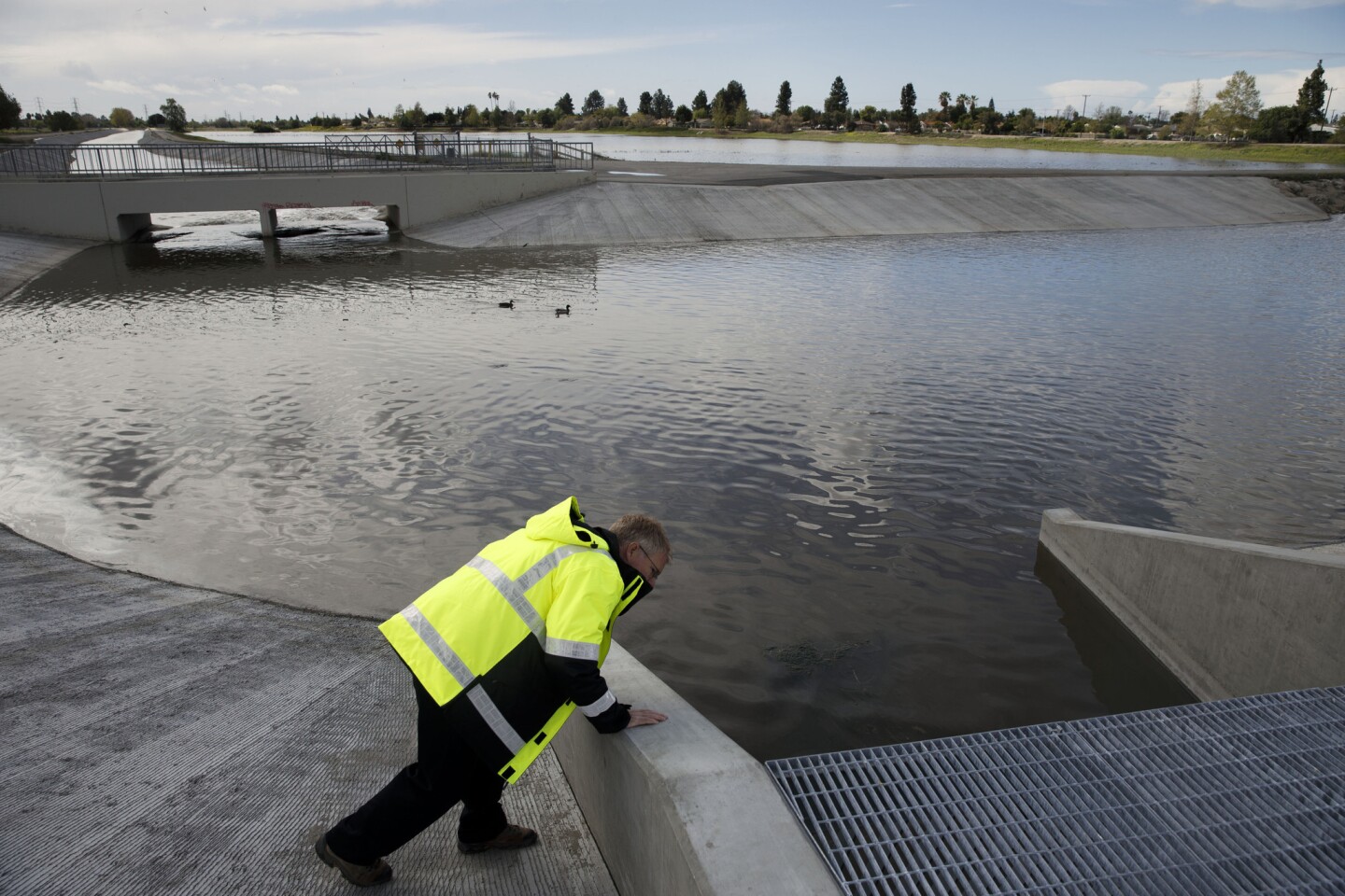 Steven Frasher, public information officer for the Los Angeles County Department of Public Works looks at water flowing from the San Gabriel River into the Paseo del Rio at San Gabriel Coast Basin spreading grounds .n Pico Rivera, Calif.