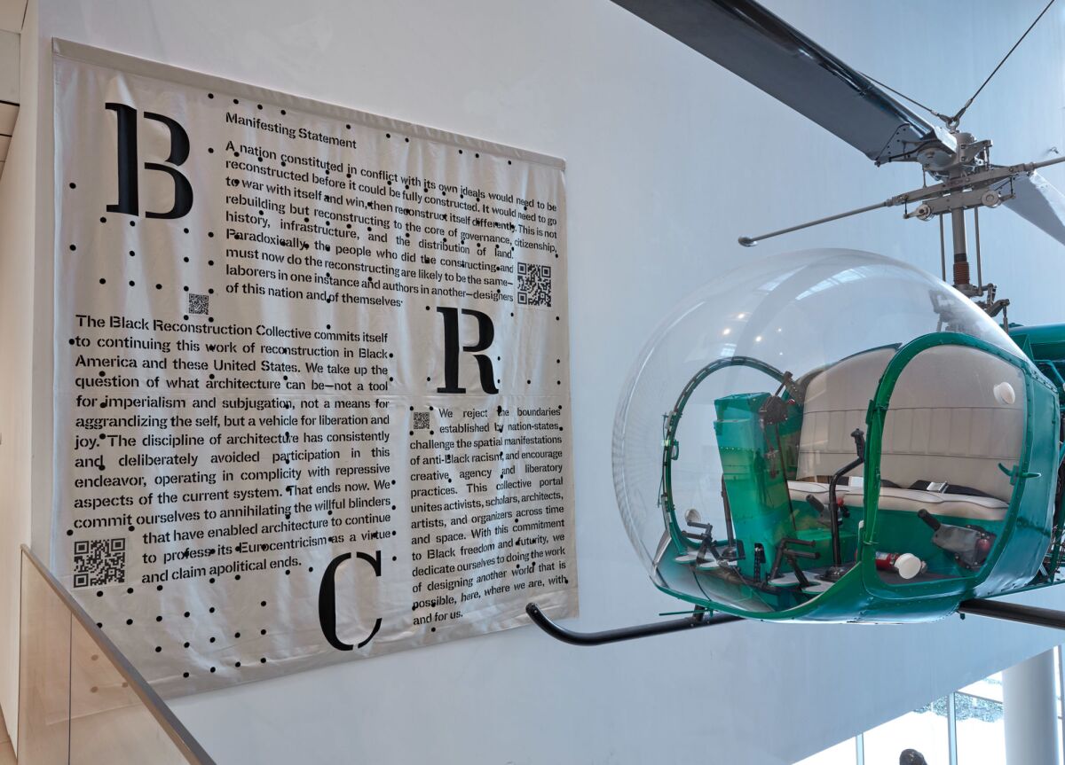 A text piece printed in fabric and suspended on a wall begins with the phrase "Manifesting Statement." 