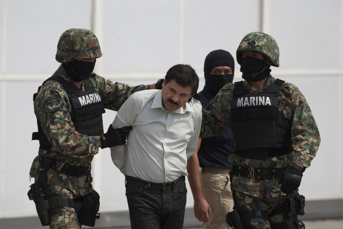 Joaquin "El Chapo" Guzman is taken to a helicopter in handcuffs by Mexican marines at a navy hangar in Mexico City.