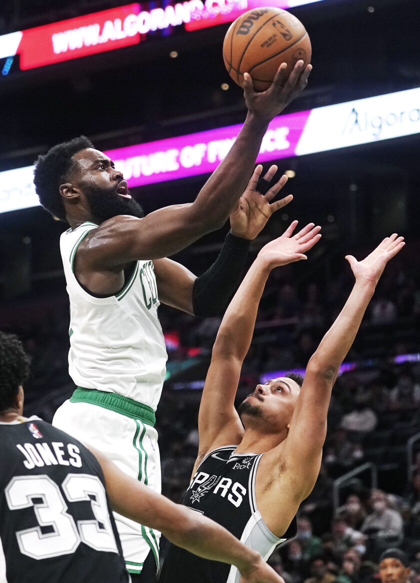 Boston Celtics guard Jaylen Brown, left, drives to the basket against San Antonio Spurs guard Bryn Forbes, right, during the first half of an NBA basketball game, Wednesday, Jan. 5, 2022, in Boston. (AP Photo/Charles Krupa)