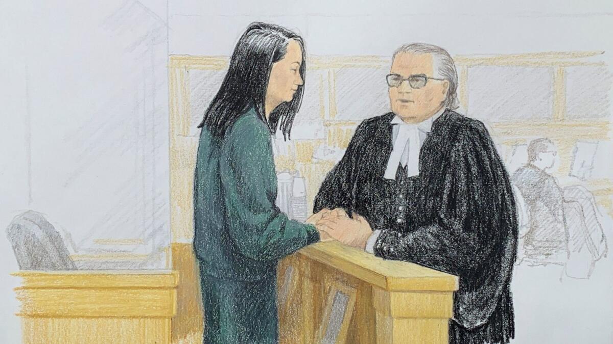In this sketch by Jane Wolsak, Meng Wanzhou, left, Huawei's chief financial officer, speaks with lawyer David Martin in a courtroom in Vancouver, Canada, on Monday.