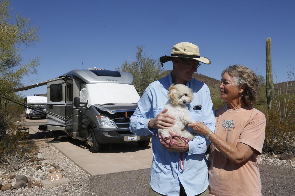 San Diego residents Frank Yancey and Barbara Deese stand with their dog Sophie at a campground at Organ Pipe National Monument.