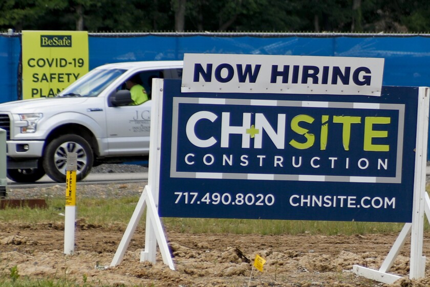 A sign at a construction site advertises job opportunities.