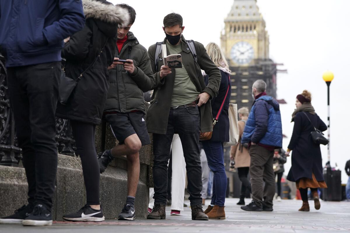 People line up along London's Westminster Bridge for COVID boosters.