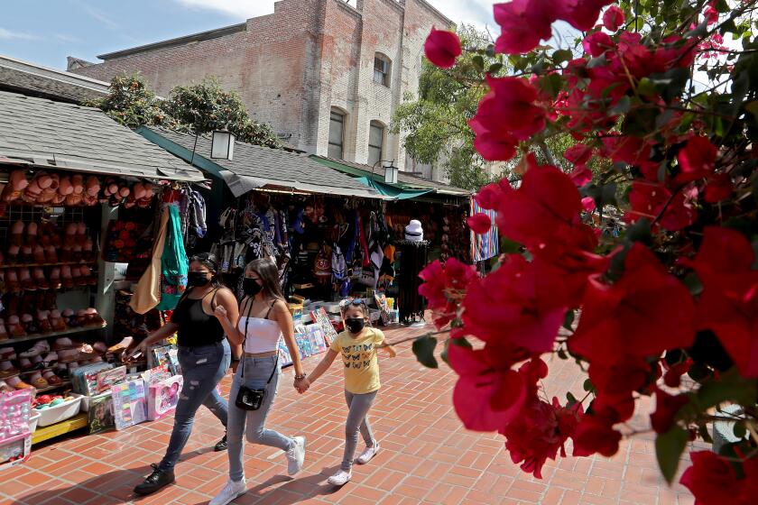 LOS ANGELES, CA - MAY 05:. Visitors wlak down Olvera Street in Los Angeles on Cinco de Mayo, Wednesday, May 5, 2021. The day commemorates the Mexican people's victory over French forces at the Battle of Puebla on May 5, 1862. The historic core of L.A. had plenty of foot traffic, but no cultural performances were presented because of the ongoing coronavirus pandemic. (Luis Sinco / Los Angeles Times)