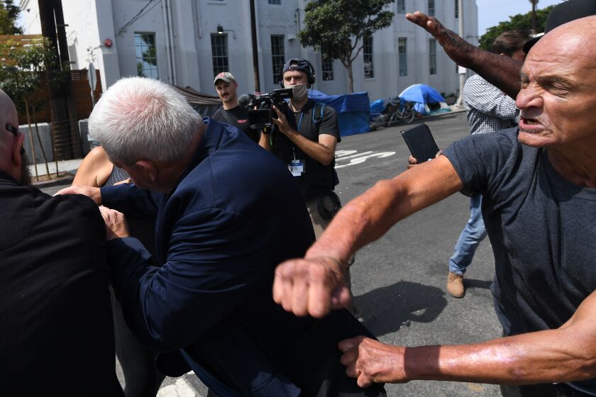VENICE, CA. September 8, 2021: A homeless man takes a swing at a staff member for Republican gubernatorial candidate Larry Elder during a tour in Venice Wednesday. (Wally Skalij/Los Angeles Times)