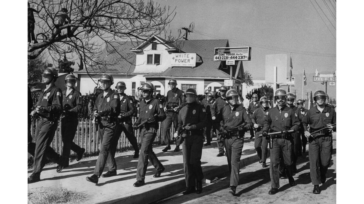 Jan. 30, 1972: Police move in to quell the disturbance when a crowd of 1,000 protesters began hurling bottles and other objects at the National Socialist White People's Party headquarters in El Monte.