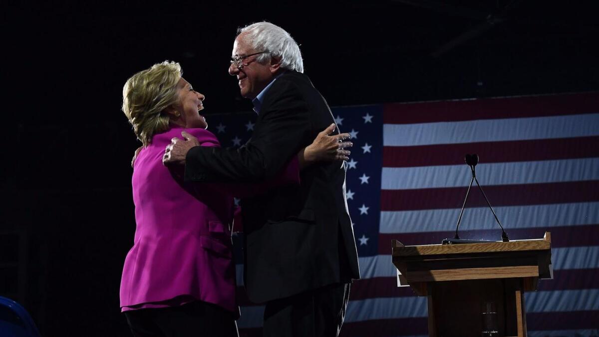Democratic presidential nominee Hillary Clinton and Vermont Sen. Bernie Sanders embrace during a campaign rally in Raleigh, N.C., on Thursday.