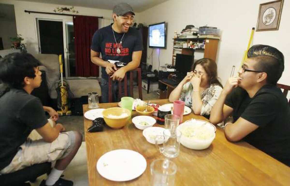 Israel, 14, from left, Isaac, 21, Lucy, and Ruben Barrera, 18, spend time together during dinner at their home in Los Angeles. Israel is the only one documented and was born here in the United States. Israel's mother, Lucy, moved to the United States from Mexicali, Mexico in 1995 with Israel's brothers, Isaac and Ruben.