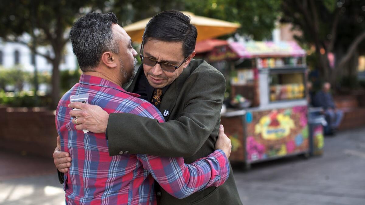 Miguel Luna, left, hugs project participant Adan Ortega, who runs a government affairs firm.