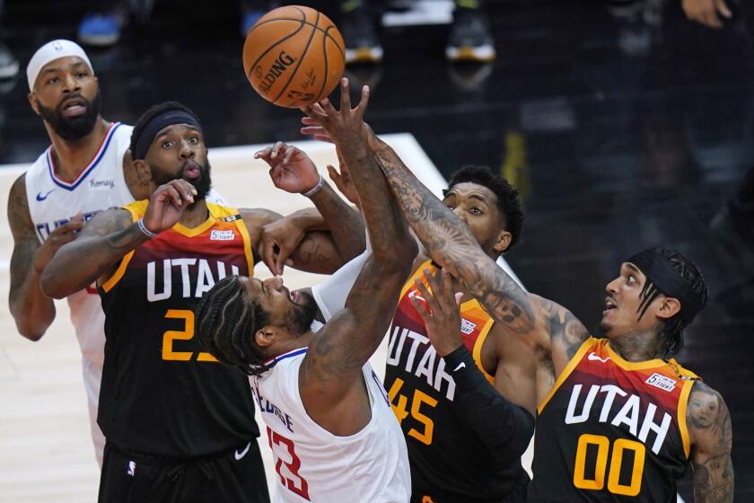 Utah Jazz's Royce O'Neale, second from left, Donovan Mitchell (45) and Jordan Clarkson (00) defend against Los Angeles Clippers guard Paul George (13) during the first half of Game 5 of a second-round NBA basketball playoff series Wednesday, June 16, 2021, in Salt Lake City. (AP Photo/Rick Bowmer)