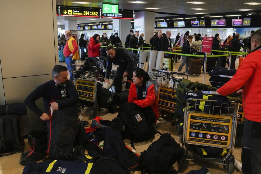Spanish firefighters with their equipment at Barajas international airport, in Madrid, Spain, Monday, Feb. 6, 2023, before boarding a flight to help with a rescue mission in Turkey. A powerful quake has knocked down multiple buildings in southeast Turkey and Syria and many casualties are feared.(AP Photo/Paul White)
