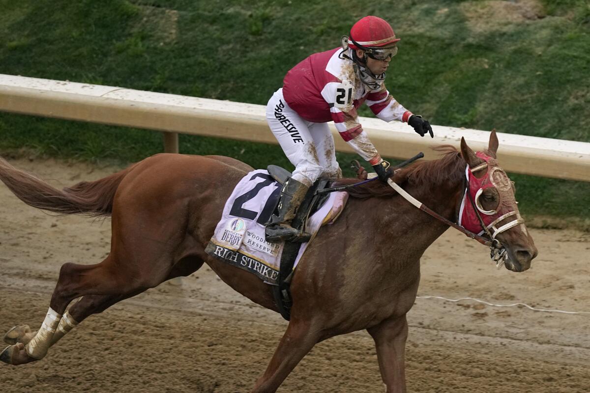 Sonny Leon celebrates after riding Rich Strike to victory in the 148th running of the Kentucky Derby