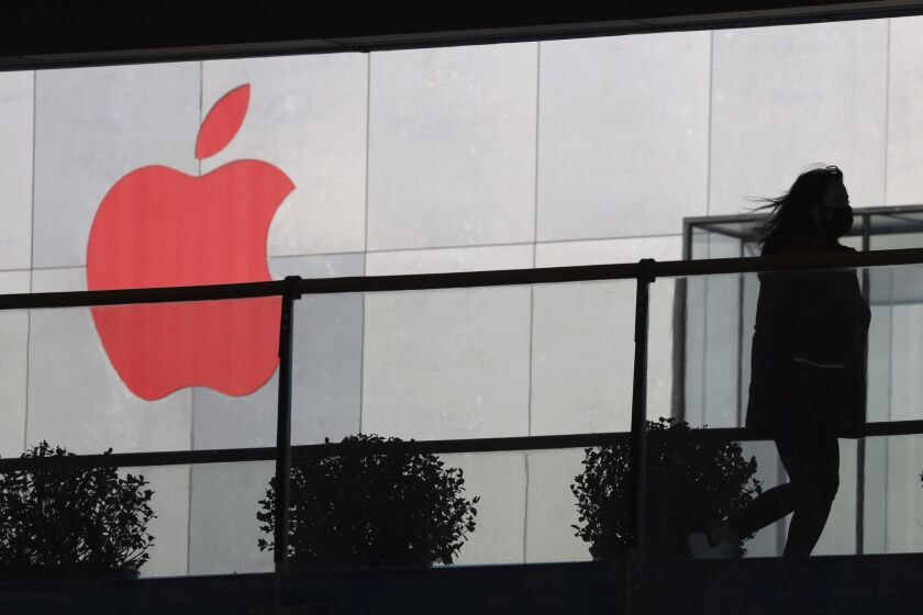 In this Dec. 6, 2018, photo, a woman runs past a Apple logo colored red in Beijing, China. Apple Inc.s $1,000 iPhone is a tough sell to Chinese consumers who are jittery over an economic slump and a trade war with Washington. The tech giant became the latest global company to collide with Chinese consumer anxiety when CEO Tim Cook said iPhone demand is waning, due mostly to China. Weak consumer demand in the worlds second-largest economy is a blow to industries from autos to designer clothing that are counting on China to drive revenue growth. (AP Photo/Ng Han Guan)