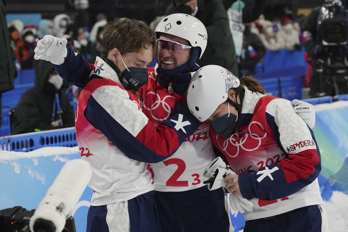 United States' Justin Schoenefeld, center, celebrates with Christopher Lillis, left, and Ashley Caldwell during the mixed team aerials finals at the 2022 Winter Olympics, Thursday, Feb. 10, 2022, in Zhangjiakou, China. (AP Photo/Gregory Bull)