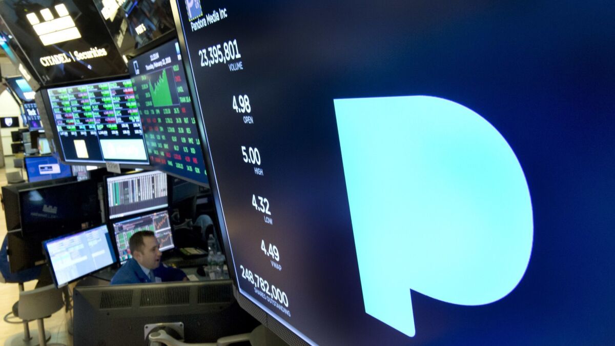 The Pandora logo appears above a trading post on the floor of the New York Stock Exchange in February 2018. Subscription radio company SiriusXM says it's buying music streaming service Pandora Media Inc. in a stock deal valued at about $3.5 billion.