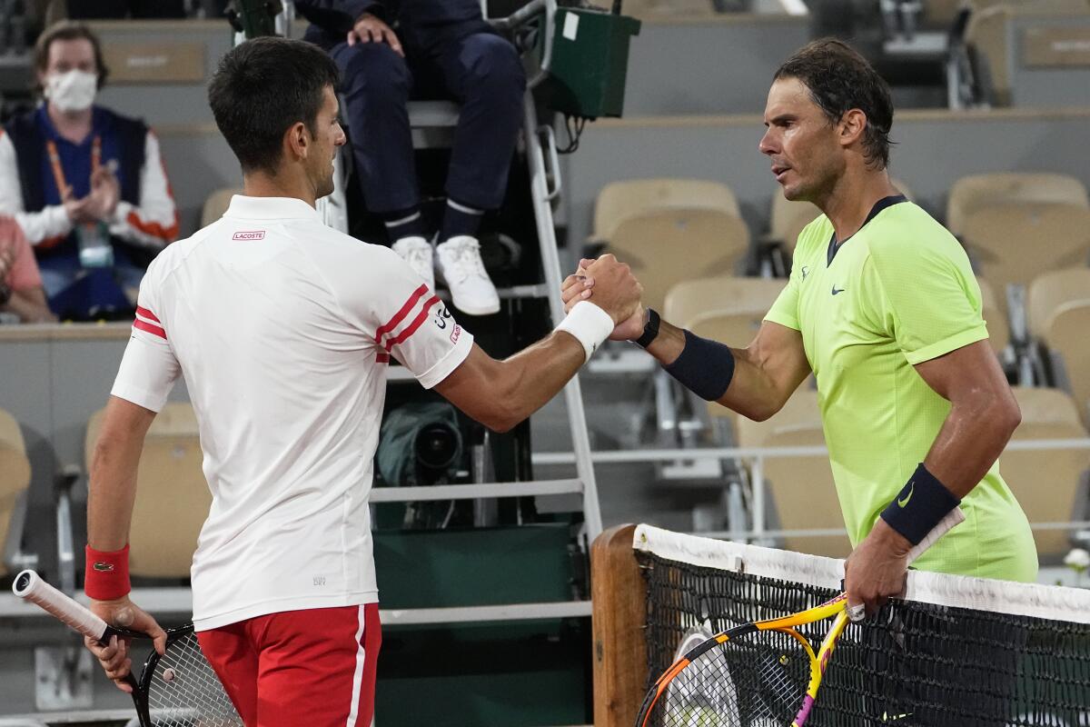ARCHIVO - Novak Djokovic (izquierda) estrecha la mano de Rafael Nadal