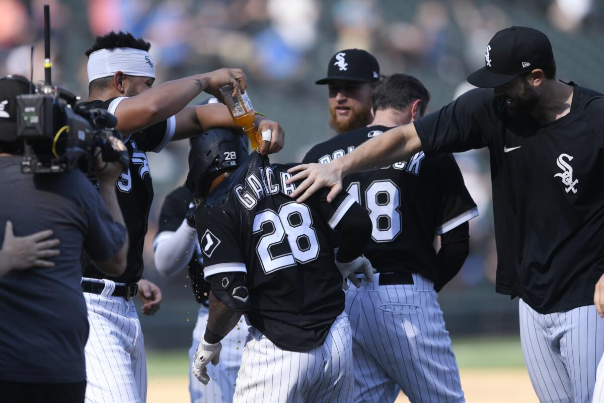 Chicago White Sox's Leury Garcia (28) is congratulated by teammates after he drove in the winning run in the 10th inning against the Minnesota Twins in a baseball game Wednesday, July 6, 2022, in Chicago. (AP Photo/Paul Beaty)